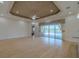 Spacious open concept living room with decorative ceiling, fan, and sliding glass doors to a pool at 16206 Diamond Bay Dr, Wimauma, FL 33598