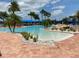 Community pool area boasts a zero entry pool, lush tropical foliage, and lots of lounge chairs at 16206 Diamond Bay Dr, Wimauma, FL 33598