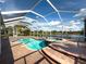 Screened-in pool with spa and brick paver deck, offering a tranquil outdoor living experience with a lake view at 16206 Diamond Bay Dr, Wimauma, FL 33598