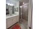 Bathroom featuring a shower with glass doors, updated vanity, and a framed mirror at 17520 Gawthrop Dr # 106, Lakewood Ranch, FL 34211