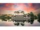 Lakewood National community entrance with lush palms and tranquil water reflections at sunset at 17520 Gawthrop Dr # 106, Lakewood Ranch, FL 34211