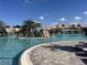 Stunning community pool featuring waterfalls, lush landscaping, inviting lounge areas, and steps for easy access at 17520 Gawthrop Dr # 106, Lakewood Ranch, FL 34211