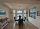Bright dining area features a chandelier, large windows overlooking the landscape, and seating for four at 17520 Gawthrop Dr # 106, Lakewood Ranch, FL 34211
