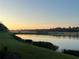 Picturesque lakeside golf course at sunrise with trees in the background at 17520 Gawthrop Dr # 106, Lakewood Ranch, FL 34211