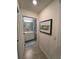 Neutral hallway leading to a full bathroom with light tile and decor at 17520 Gawthrop Dr # 106, Lakewood Ranch, FL 34211