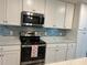 Bright kitchen with stainless steel appliances, white cabinets, and a decorative tile backsplash at 17520 Gawthrop Dr # 106, Lakewood Ranch, FL 34211