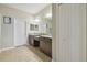 Bathroom with double granite sinks, cabinets, large mirror, and tiled floor at 19317 Hawk Valley Dr, Tampa, FL 33647