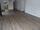 Open living room with hardwood floors showing access to kitchen and a side bedroom at 2623 Seville Blvd # 111, Clearwater, FL 33764