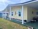 Delightful yellow home featuring a covered porch, manicured lawn, and charming accents at 35020 Colony Hills Dr, Zephyrhills, FL 33541