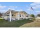 Inviting home featuring an American flag, covered porch, and well-maintained lawn at 35020 Colony Hills Dr, Zephyrhills, FL 33541