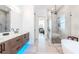 Sleek bathroom with double vanity, frameless glass shower and separate soaking tub at 4604 W Lowell Ave, Tampa, FL 33629
