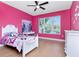 Pink bedroom features a large window, ceiling fan, and wood flooring at 4604 W Lowell Ave, Tampa, FL 33629