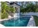 Beautiful pool with a spa and patio alongside tropical landscaping and contemporary architecture at 4604 W Lowell Ave, Tampa, FL 33629