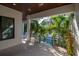 Outdoor view with a covered deck and view of the pool surrounded by lush palms at 4604 W Lowell Ave, Tampa, FL 33629