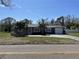 Charming single story home with manicured lawn, palm trees, and a long driveway leading to an attached garage at 561 Park S St, St Petersburg, FL 33707