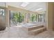A stunning bathroom featuring a soaking tub, large windows, and a glass-enclosed shower at 70 Deerpath Dr, Oldsmar, FL 34677