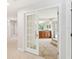 Bathroom view through white French doors, featuring wood cabinets and tiled walk-in shower at 70 Deerpath Dr, Oldsmar, FL 34677