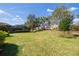 Expansive backyard with a screened-in lanai, lush lawn, and a decorative perimeter wall at 11563 Callisia Dr, Odessa, FL 33556
