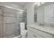 Well-lit bathroom featuring a granite vanity top, a toilet, and a glass-enclosed tile shower at 11563 Callisia Dr, Odessa, FL 33556