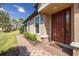 Inviting front entryway with a brick paver walkway and charming, well-maintained landscaping at 11563 Callisia Dr, Odessa, FL 33556
