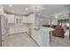 Open-concept kitchen with stainless appliances, white cabinetry, and a breakfast bar overlooking the living area at 11563 Callisia Dr, Odessa, FL 33556