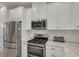 Well-equipped kitchen featuring stainless steel appliances, a gas range, and a stylish tile backsplash at 11563 Callisia Dr, Odessa, FL 33556