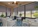 Enclosed lanai offering a relaxing space with wicker furniture and views of the backyard at 11563 Callisia Dr, Odessa, FL 33556