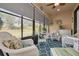 Relaxing enclosed lanai with wicker furniture, ceiling fan, and tranquil views of the surrounding landscape at 11563 Callisia Dr, Odessa, FL 33556
