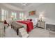 Bright main bedroom with tray ceilings, a chandelier, a decorative headboard, and a cozy bench at 11563 Callisia Dr, Odessa, FL 33556