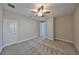 Neutral bedroom with patterned gray carpet, ceiling fan, and two entry doors at 12779 Fisherville Way, Riverview, FL 33579