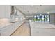 The modern kitchen offers white cabinetry, a subway tile backsplash, stainless steel appliances, and a spacious island at 12779 Fisherville Way, Riverview, FL 33579