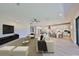 Open-concept living room showcases bright interior with kitchen, modern furniture, and sleek entertainment setup at 12779 Fisherville Way, Riverview, FL 33579