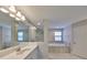 Luxurious main bathroom with dual vanity, soaking tub, and walk-in shower at 12779 Fisherville Way, Riverview, FL 33579