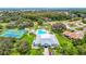 Aerial view of community center, pool, and tennis courts surrounded by manicured landscaping and trees at 13252 Norman Cir, Hudson, FL 34669