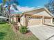 Charming single-story home featuring a three car garage, manicured lawn, and welcoming front entrance at 13252 Norman Cir, Hudson, FL 34669