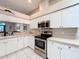 Modern kitchen with stainless steel appliances, white cabinets, and neutral countertops for a sleek, contemporary look at 13252 Norman Cir, Hudson, FL 34669