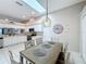 Eat-in kitchen featuring stainless steel appliances, white cabinetry, a skylight and a casual dining area at 13252 Norman Cir, Hudson, FL 34669