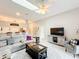 Spacious living room featuring a large sectional, neutral paint, skylight, and an open view of the kitchen at 13252 Norman Cir, Hudson, FL 34669