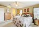 Main bedroom with access to the bath, neutral tones, palm art and a king bed with access to the lanai at 13252 Norman Cir, Hudson, FL 34669