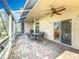 Relaxing screened patio with brick flooring, ceiling fans, and dining set for outdoor living and entertaining at 13252 Norman Cir, Hudson, FL 34669
