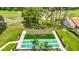 Aerial view of well-maintained pickleball courts with seating and landscaping in a serene community setting at 13252 Norman Cir, Hudson, FL 34669