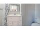 Bathroom showcasing a white vanity, framed mirror, and a clean toilet, for comfort and convenience at 15701 Springmoss Ln, Tampa, FL 33624