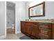 Bathroom featuring a wood vanity with a marble countertop, a decorative mirror, and neutral flooring at 15701 Springmoss Ln, Tampa, FL 33624