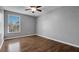 Bright bedroom with wood floors, large window, and ceiling fan providing a welcoming space at 15701 Springmoss Ln, Tampa, FL 33624