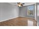 Well-lit bedroom with a ceiling fan, wood-look floors, and a large window for natural light at 15701 Springmoss Ln, Tampa, FL 33624