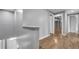 Hallway with wood floors leads to bedrooms and bathrooms featuring closet and storage at 15701 Springmoss Ln, Tampa, FL 33624