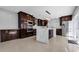 Modern kitchen with large central island, stainless steel appliances, and dark wood cabinets at 15701 Springmoss Ln, Tampa, FL 33624