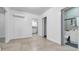 Open living room featuring tile floors, modern air conditioning, and easy access to the bathroom at 15701 Springmoss Ln, Tampa, FL 33624