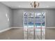 Bright living room with tiled flooring, chandelier, and a view of the pool through sliding glass doors at 15701 Springmoss Ln, Tampa, FL 33624
