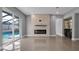 Open-concept living room featuring a modern fireplace, bar area, and access to the pool at 15701 Springmoss Ln, Tampa, FL 33624